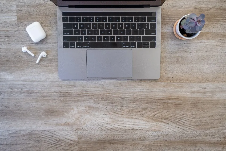 Portátil y auriculares sobre una mesa de madera